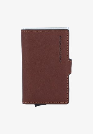 Bruine leren portemonnee met een gestructureerde afwerking, voorzien van metalen accenten, gestikte randen en een reliëflogo aan de zijkant. Compacter ontwerp.