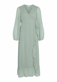 Mintgrønn innpakket kjole laget av lett stoff, med prikker, lange gjennomsiktige ermer, en volangdetalj på siden og utvidet kant.