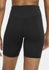 Black high-waisted bike shorts made of stretchy fabric. Smooth texture with no visible patterns or hardware, finishing above the knee.