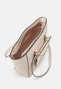 Beige taška s černými detaily, texturovaný vzhled umělé kůže, zlaté kování, vnitřní kapsa a hladká podšívka s diamantovým vzorem.