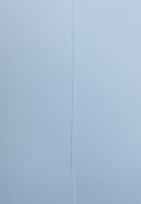 Lichtblauwe rekbare stof met een gladde textuur en een verticale naad die in het midden loopt. Geen patronen of extra accenten aanwezig.