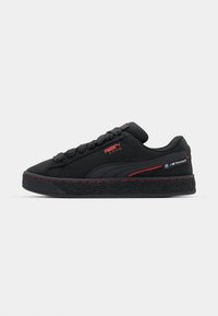 Black Puma Suede XL sneaker with red accents, BMW Motorsport logo on heel, and black textured sole, side view on white background.