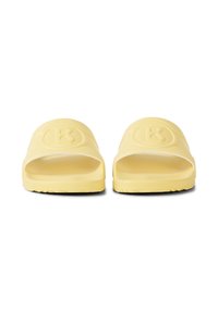 Paire de sandales en caoutchouc jaunes à enfiler avec de larges brides présentant un logo circulaire en relief, vues de face sur fond blanc.