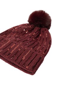 Burgundijas krāsas adīta cepure ar ribotu rakstu, spīdīgām pērļu detaļām visā virsmā un lielu pūkainu pom-pomu augšpusē.