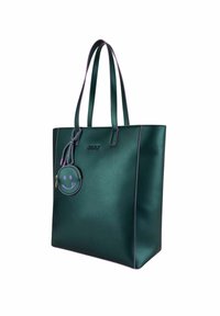 Sac fourre-tout vert avec des accents violets, fabriqué en matériau lisse. Présente de longues poignées et une pochette ronde zippée avec un design de smiley.