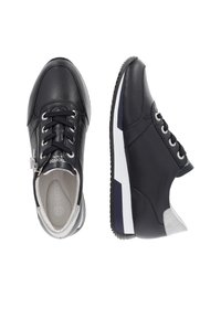 Baskets en cuir noir avec lacets noirs, fermeture éclair latérale, détails blancs et gris, vues de dessus et de côté sur fond blanc.