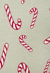 Lys grått stoff med gjentatte røde og hvite pepperkakemønstre og en teksturert strikkeoverflate.