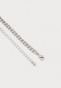 Due chiusure di collana in argento su sfondo bianco, una con grandi anelli ovali e una chiusura a gabbiano, l'altra con piccoli anelli rotondi.