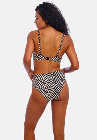 Zwart-witte bikini set met zebra-strepen, bestaande uit een bralette-top met verstelbare bandjes en een hooggeoriënteerde onderkant. Gladde stoftextuur.