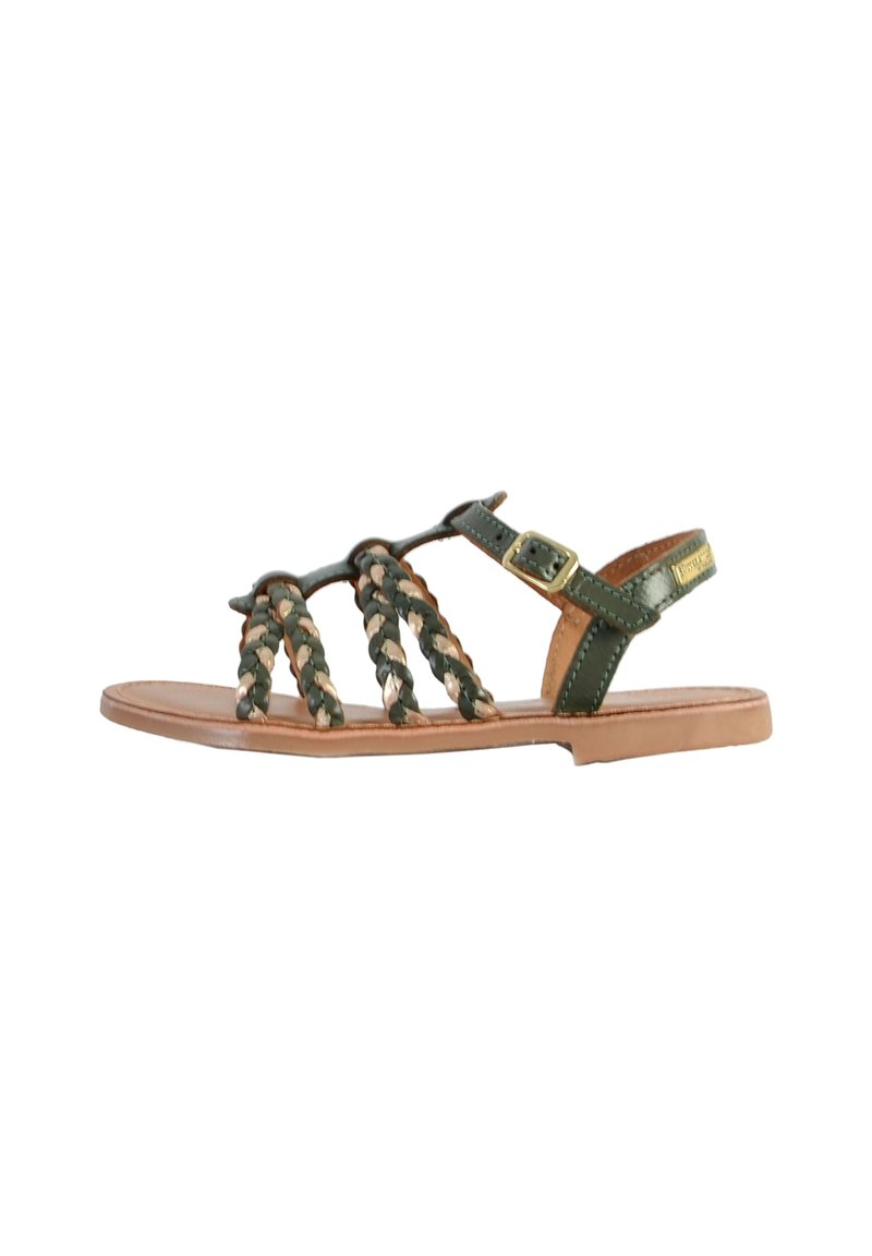 Groene gevlochten leren sandalen met een platte tan zool, voorzien van een enkelbandje en metalen gesp voor een veilige pasvorm. De gestructureerde geweven details vallen op.