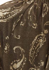 Tissu brun à motifs avec un design paisley dans une teinte plus claire. La texture semble lisse avec un léger éclat, ce qui le rend adapté aux vêtements.