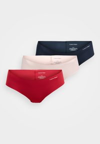 Trei perechi de lenjerie intimă stil hipster fără cusături de la Calvin Klein, în culorile roșu, roz deschis și albastru închis, așezate pe un fundal alb.