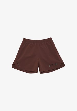 Man wearing maroon long-sleeve shirt, matching shorts with black "ATW" text, white socks, and gray running shoes, standing against gray background.