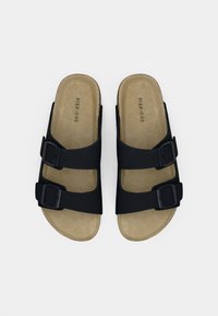 Μαύρα σανδάλια με δύο ρυθμιζόμενους ιμάντες με αγκράφες, μαλακό μπεζ πέλμα και ομαλή επιφάνεια. Το όνομα της μάρκας "PIER ONE" είναι ορατό στο πέλμα.