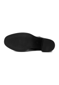 Suela de zapato negra con un patrón texturizado, que presenta un borde liso y una ligera curvatura. El material de goma ofrece agarre y durabilidad.