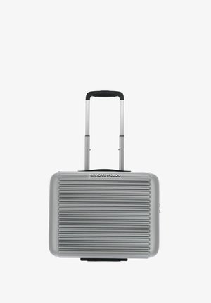 Walizka twarda w kolorze srebrnym z poziomymi rowkami, z wysuwaną rączką i czarnymi akcentami, z logo z przodu.