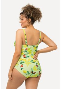 Maillot de bain une pièce à imprimé floral vert avec des motifs de citron et de baies, bretelles ajustables et une conception ajustée. Tissu texturé.