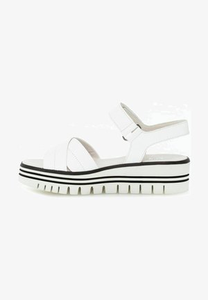 Weiße Sandalen mit breiten Kreuzriemen, einem hinten gelegenen Riemen und einer Gummisohle mit schwarzen horizontalen Streifen. Strukturiertes Obermaterial für besseren Grip.