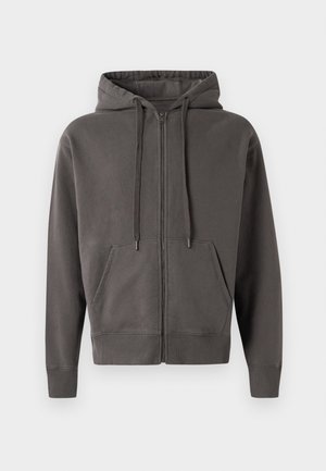 Haut à zipper gris avec capuche à cordon, poches kangourou, et poignets et ourlet côtelés. Matériau doux avec une texture lisse.