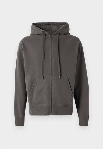 Grå zip-up hoodie med snoretræk i huen, kenguruposer og ribstrikkede manchetter og kant. Blødt materiale med en glat tekstur.