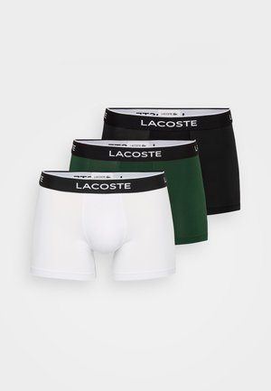 Három pár férfi boxer, fekete elasztikus derékpánttal, rajta a "LACOSTE" márkanevével. Színek: fehér, zöld és fekete. Pamut keverék anyag.