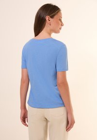 T-shirt azzurro a maniche corte con scollatura tonda, realizzato in tessuto morbido. Design semplice con dettagli di cucitura minimi sull'orlo.