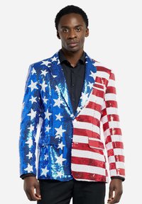 Pailletten blazermantel met blauw en witte sterren aan de ene kant en rood-witte strepen aan de andere kant. Gestructureerd ontwerp, met gegarneerde revers en enkel knoopsluiting.