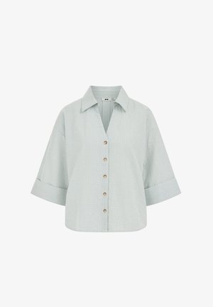 Chemise à boutons à fines rayures vert clair et blanc, avec des manches larges trois-quarts et un col large.