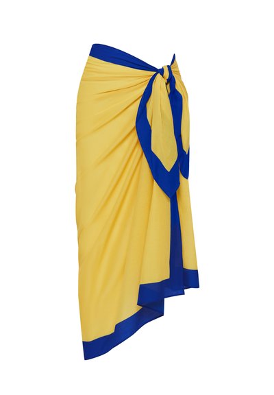 Κίτρινη φούστα που δένει, με μπλε περιθώριο και λεπτομέρεια δεμένου κόμπου. Κατασκευασμένη από ελαφρύ ύφασμα, με απαλή υφή και ρέουσα σχεδίαση.