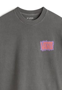 Grijze losse t-shirt met een textuur en uitgesneden stijl van het roze en paarse "VANS" logo op de borst. Zacht stof met een klassieke ronde hals.