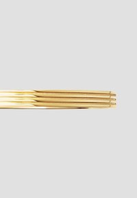 Gold bangles with a smooth, polished finish, featuring multiple thin, rounded bands stacked closely together.