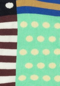 Strickstoff in mehreren Farben: dunkelblau, braun, weiße Streifen und mintgrün mit gleichmäßig angeordneten gemusterten gelben Punkten.