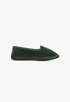 Scarpa da uomo slip-on in velluto verde con punta affusolata, senza hardware visibile, e suola in gomma testurizzata. La parte superiore ha una finitura liscia.