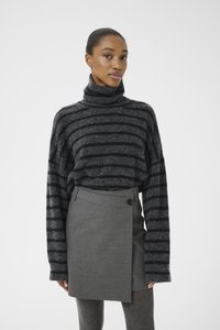 Oversized black and gray striped turtleneck sweater with a textured finish, paired with a gray wrap skirt featuring a button detail.