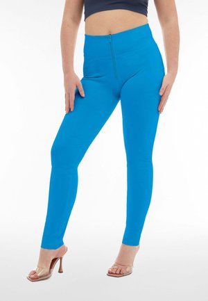 Leggings a vita alta, aderenti, realizzati in materiale blu brillante con dettaglio della cerniera frontale. Finitura testurizzata, vestibilità aderente e design della gamba affusolata.