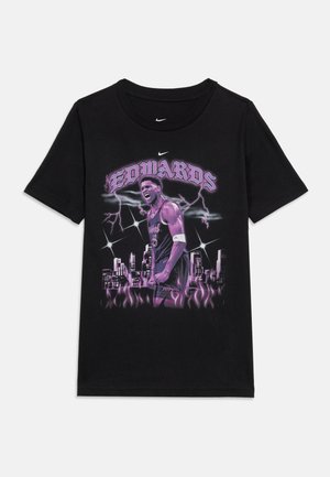 Svart T-skjorte med en grafikk av en basketballspiller merket "Edwards", lyn, bysilhuett og lilla flammer nederst.