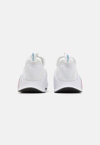 Zapatillas blancas con parte superior texturizada, talón liso y acentos coloridos a los lados. Incluyen un cuello acolchado y una lengüeta.