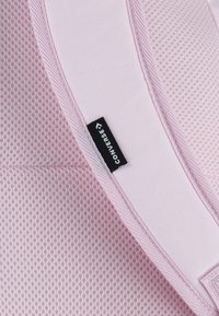 Rosa nätmaterial med ett rutmönster, accentuerat med en slät rosa kant. En liten svart etikett visar "Converse"-logotypen.