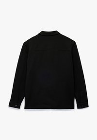 Camisa negra de manga larga con cuello, elaborada con una tela suave. Presenta una costura central en la parte posterior y puños abotonados.