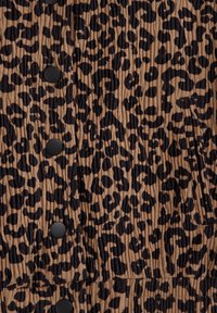 Djurmotiv klänning med brun bas och svarta leopardfläckar, ribbad textur och svarta knappar framtill.