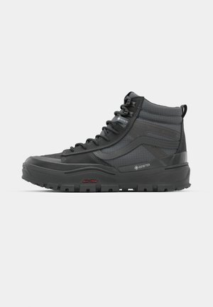 GORE-TEX crne poluvisoke planinarske cipele s teksturiranom površinom, vezanjem i čvrstim gumeni potplat s izraženim uzorkom za prianjanje.