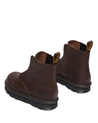 Brune lær ankle boots med elastiske sidestykker, runde tær, gule sting og sorte gummisåler. Texturert overflate med en glatt finish.