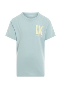 Camiseta de algodón azul claro con mangas cortas y cuello redondo. En la parte delantera presenta un gran logo amarillo "CK" junto con el texto "CalvinKleinJeans".