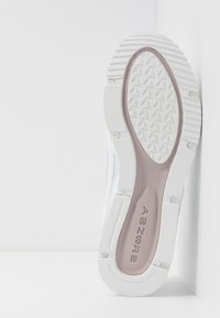 Semelle de basket blanche avec grip texturé, bande de roulement à motif ovale et logo d’amorti « ABZORB » au centre sur la zone de la semelle intérieure violet clair.