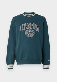 Tyrkysová mikina s kulatým výstřihem a žebrovanými manžetami. Obsahuje logo a emblém "CHAMPION" v béžové barvě, s detaily zlatého vavřínu.