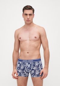 Boxer da uomo in navy con motivi floreali e astratti bianchi, dotati di un elastico con logo in navy e argento. Realizzati in tessuto morbido e elasticizzato.