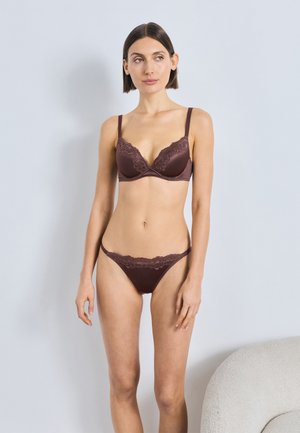 Bruine lingerie set van kant en stof met een licht gevoerde beha met kanten rand en bijpassende string, met een minimalistisch ontwerp.