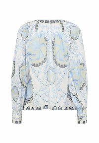 Blouse à manches longues avec motif floral bleu et beige, encolure froncée et poignets boutonnés sur tissu blanc.