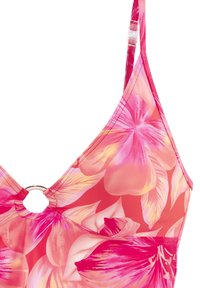 Bikini zgornji del z visokim ovratnikom, ki ima velike rožnate cvetlične vzorce na koralni podlagi, okroglo kovinsko obrobo in nastavljive naramnice.
