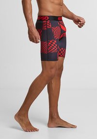 Boxers noirs pour homme avec un motif écossais rouge, ceinture élastique avec logo, et tissu doux et extensible pour le confort.